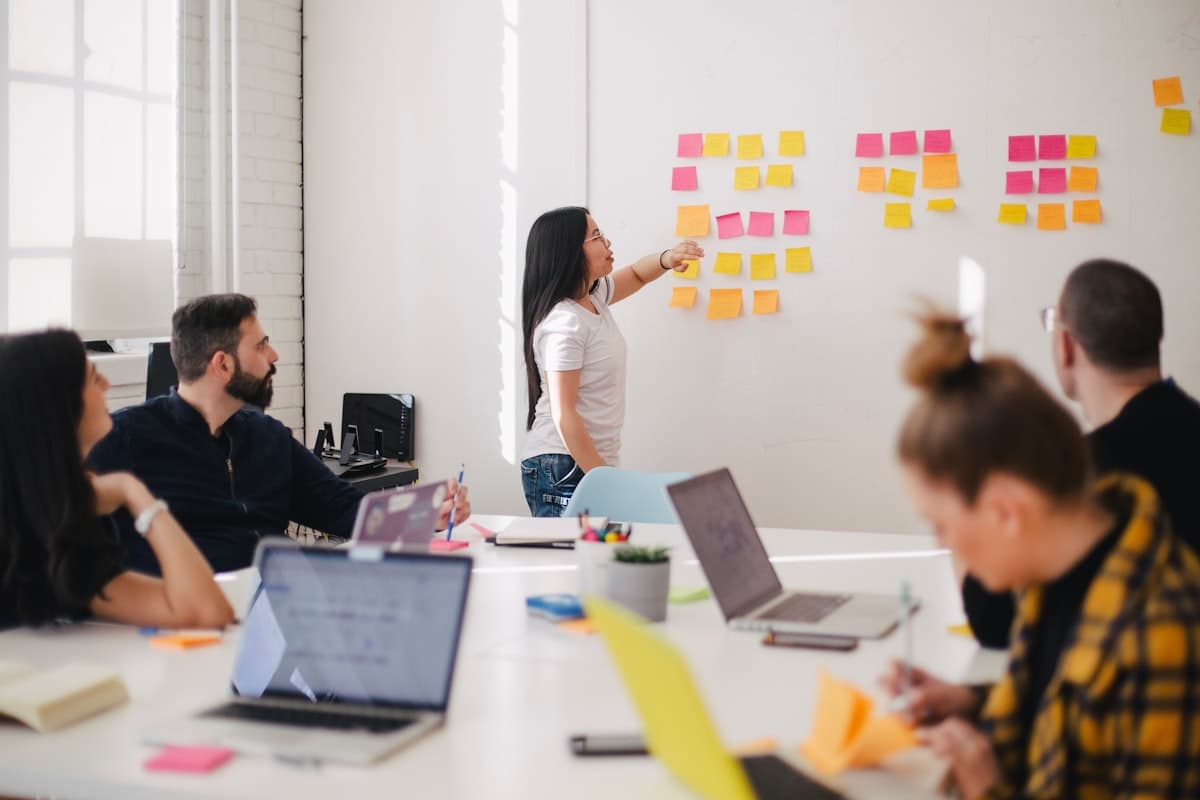 A team in a workshop mapping relationships with sticky notes on a wall.